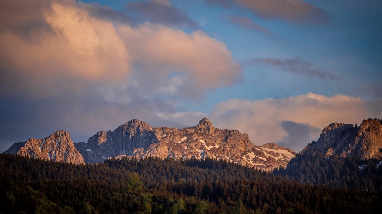 Breathtaking Alpine Sunset: Majestic Peaks and Golden Clouds