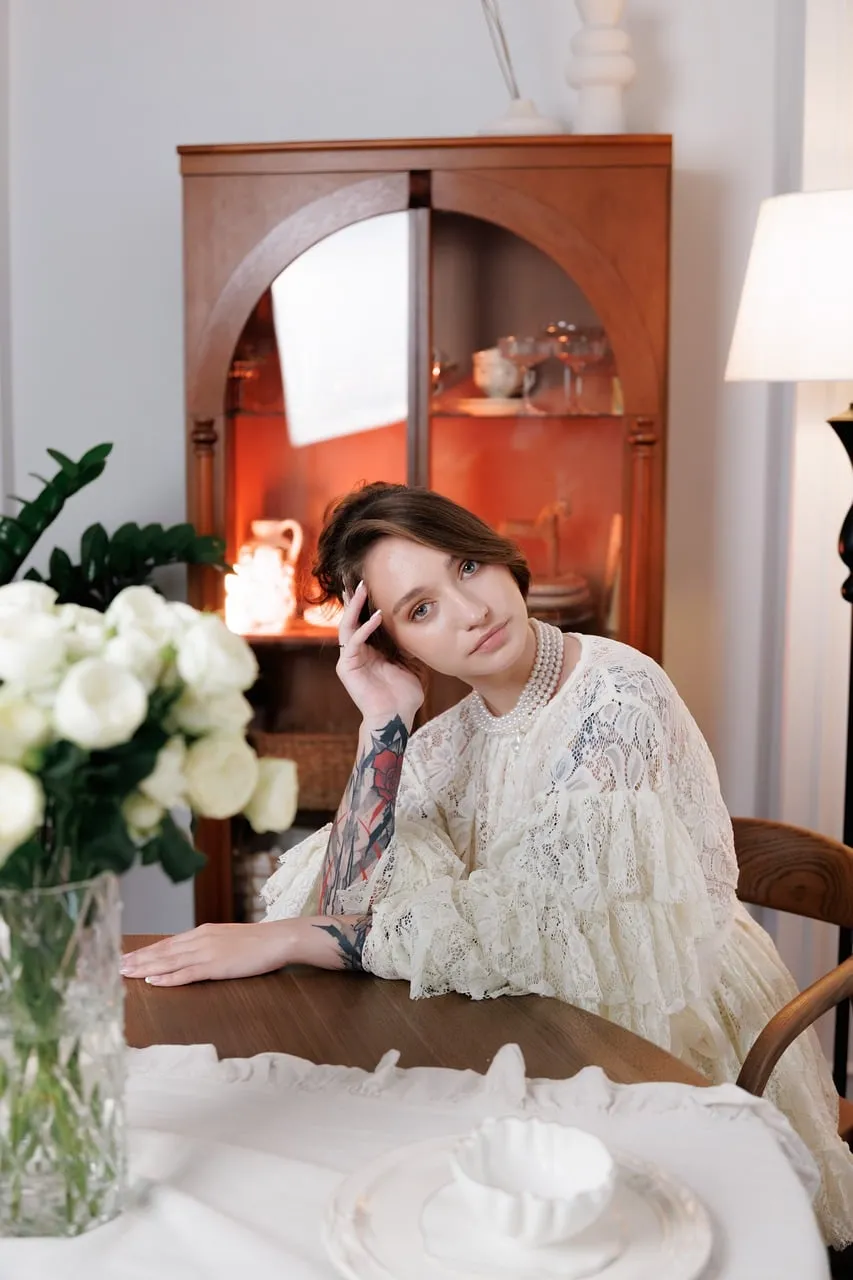 Elegant Serenity: Woman in Lace and Pearls Amidst White Roses