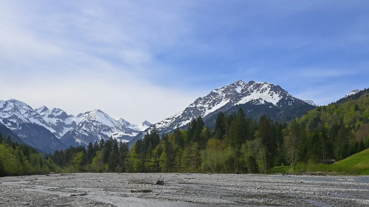Majestic Alpine Panorama: Snow-Capped Peaks and Serene River Valley