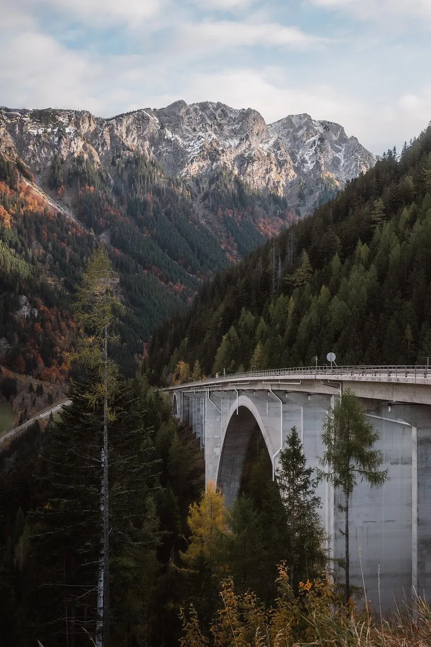 Majestic Alpine Bridge: Engineering Marvel in Autumn Mountains