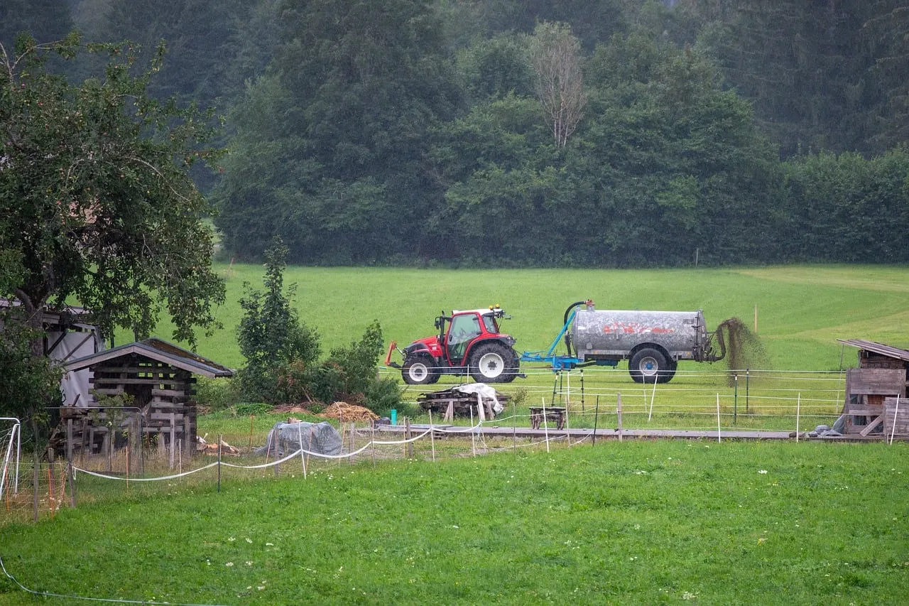 Rustic Charm: Tractor Spreading Manure in Lush Mountain Pastures