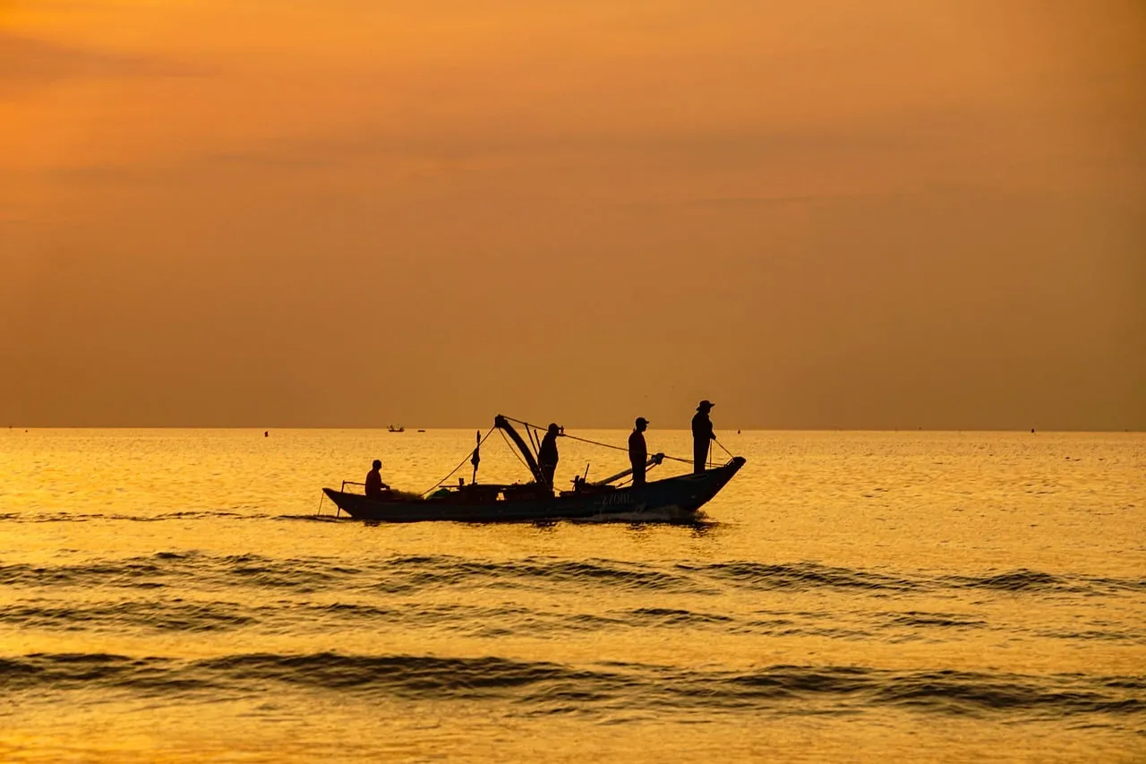 Golden Dawn: Silhouetted Fishing Boat on a Calm Sea
