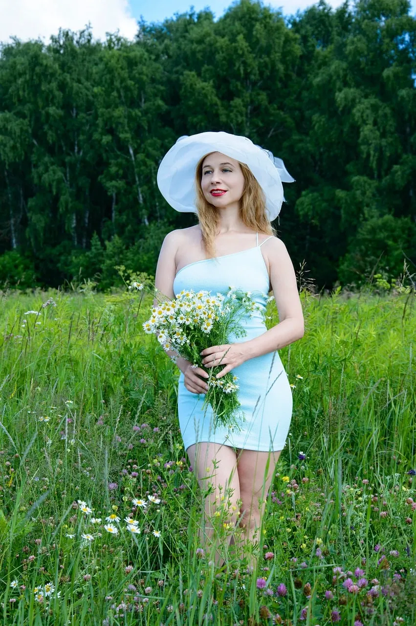 Enchanting Woman in Blue Dress Amidst Summer Wildflowers