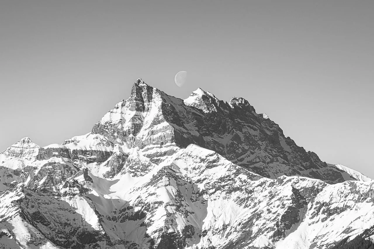 Majestic Alpine Peaks Under a Crescent Moon