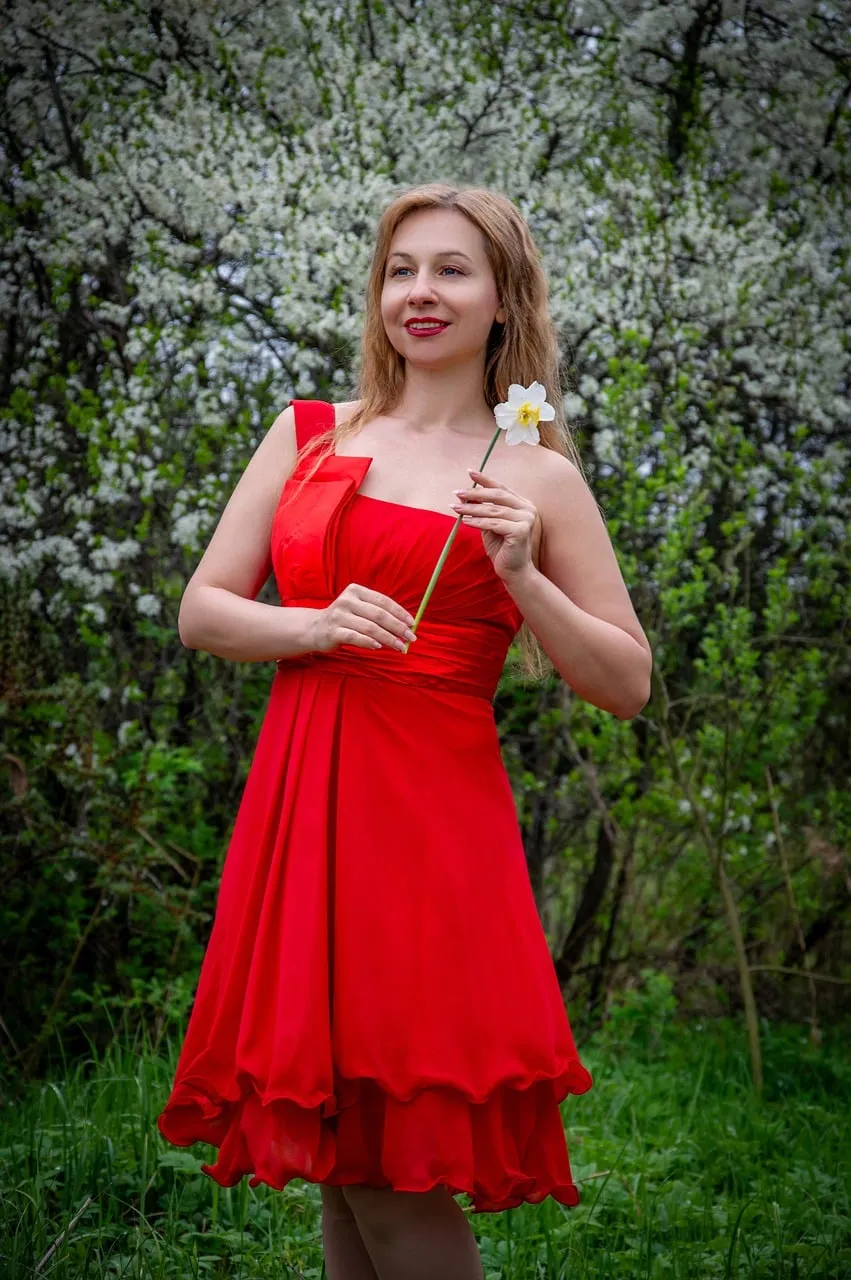 Radiant Spring Beauty: Woman in Red Amidst Blossoms