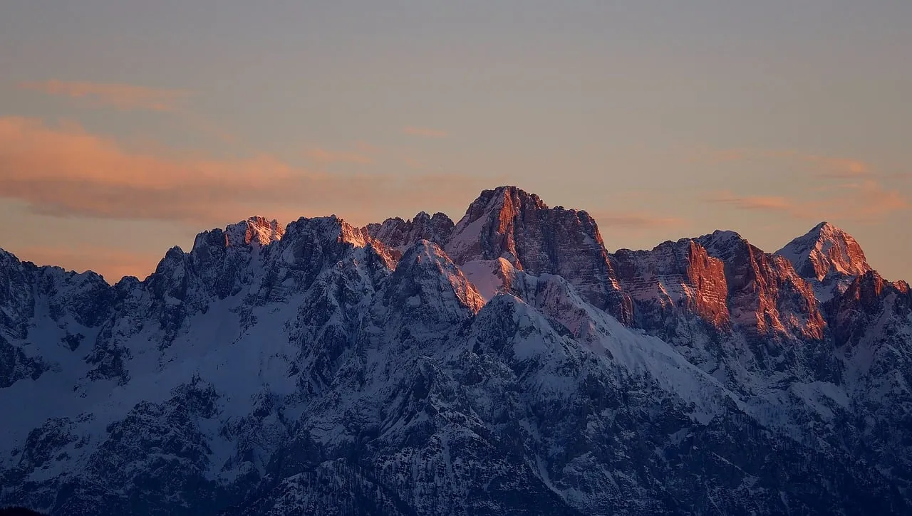 Dramatic Alpine Dawn: Snow-Capped Peaks Ablaze with Sunrise Glow