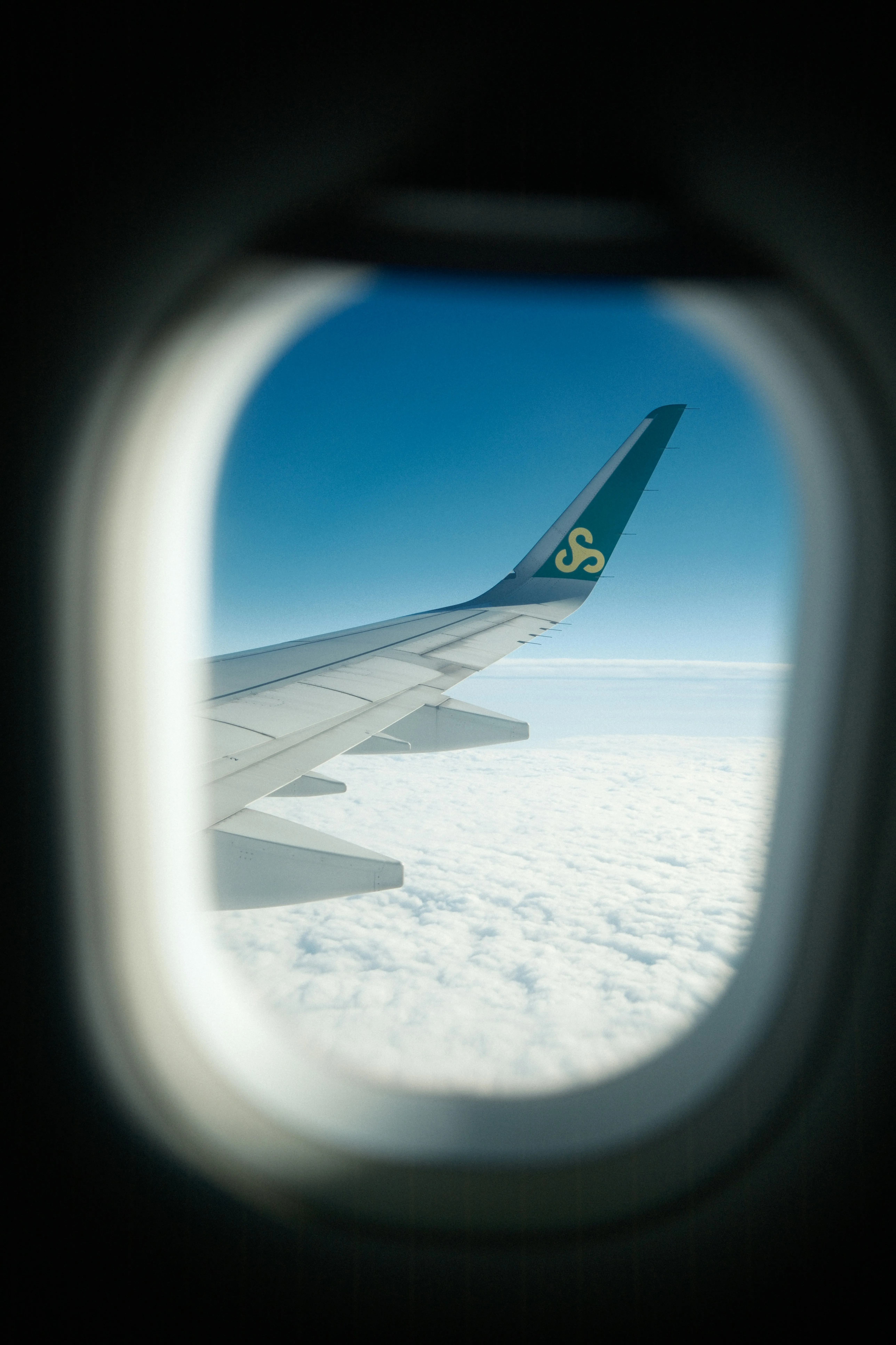 Breathtaking Flight: Wing View Above Serene Clouds