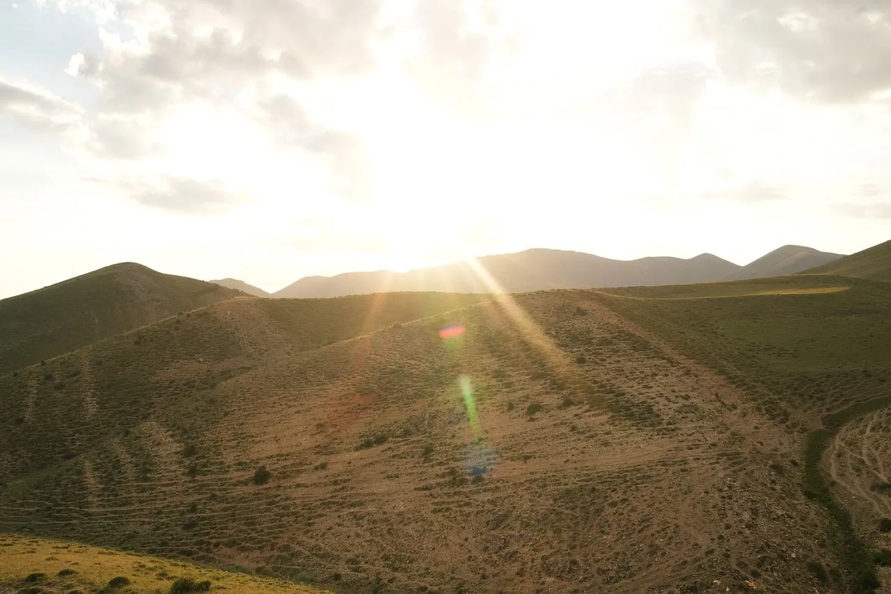 Breathtaking Mountain Sunset: Golden Rays Over Tranquil Hills