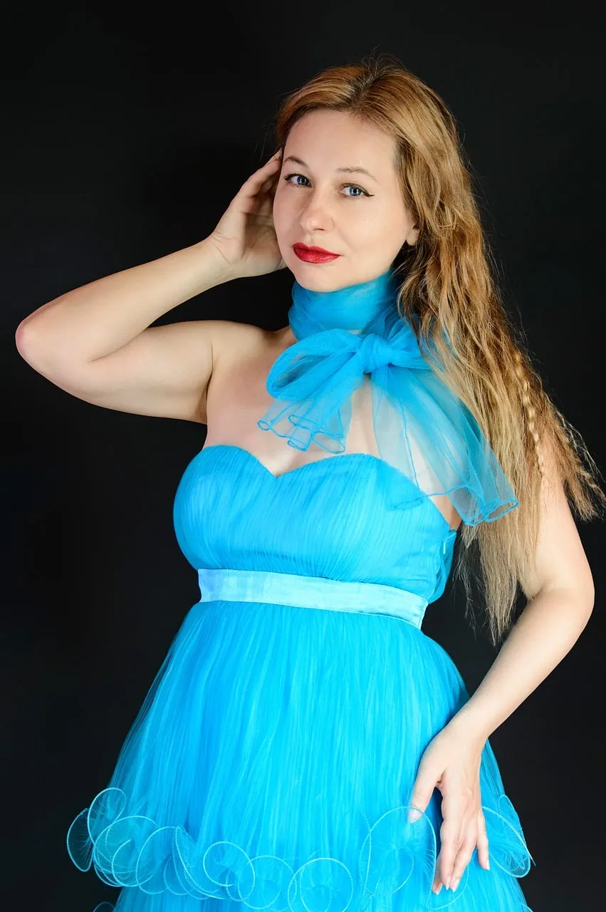 Stunning Blonde in Radiant Blue Gown on Dark Background