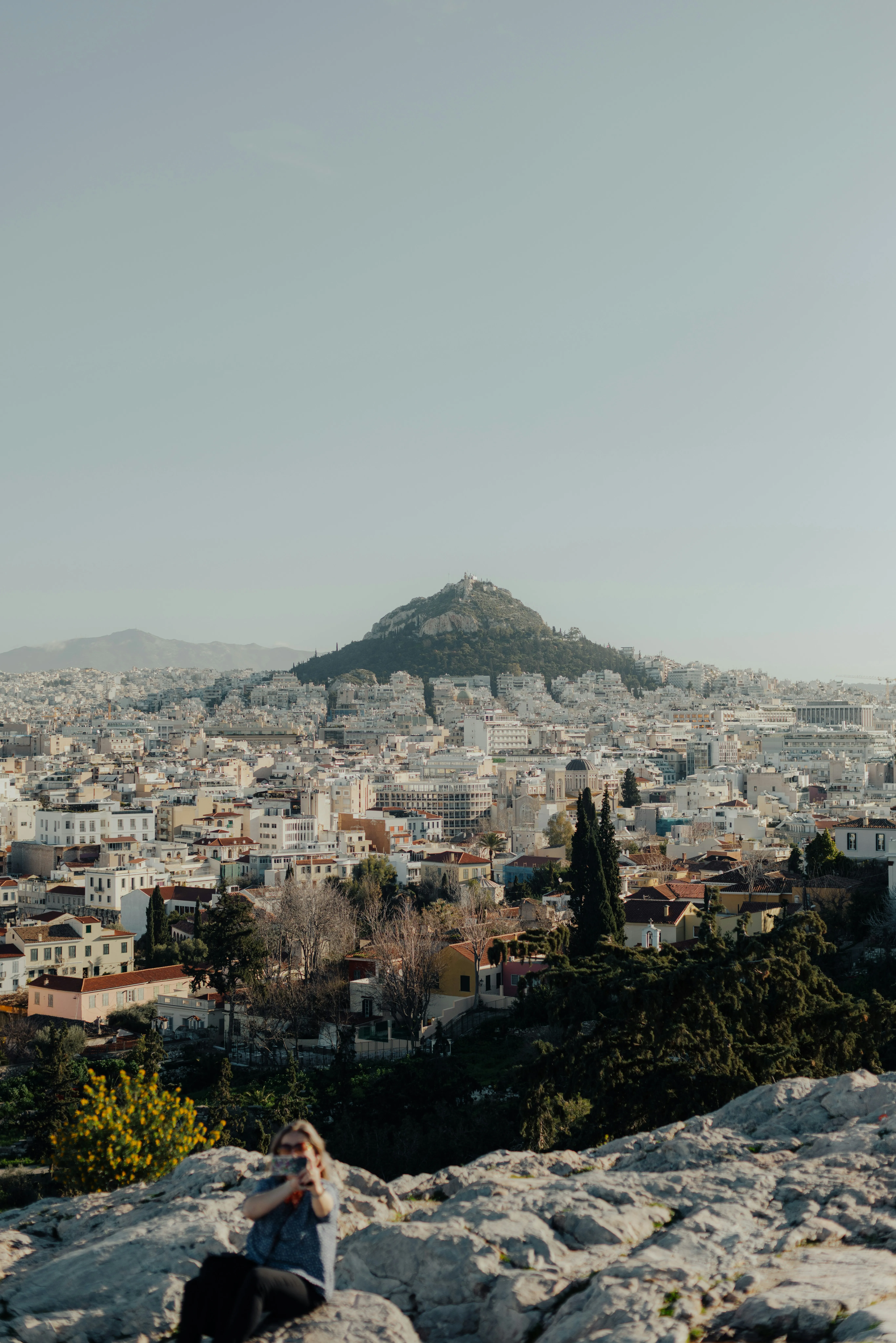 Breathtaking Cityscape: Woman Overlooking Mountain Metropolis