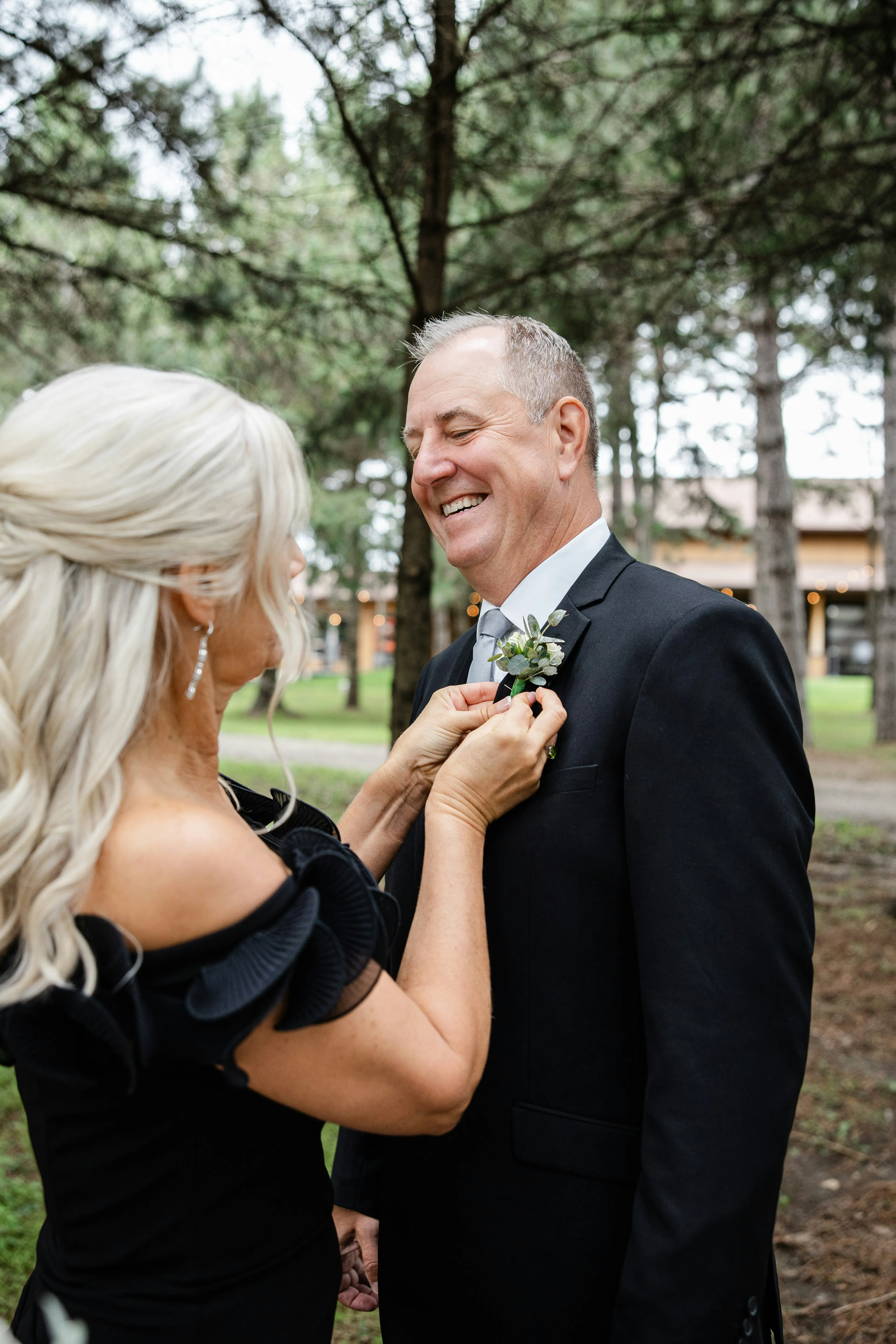 Joyful Moments: Woman Adorns Man's Suit with Boutonniere