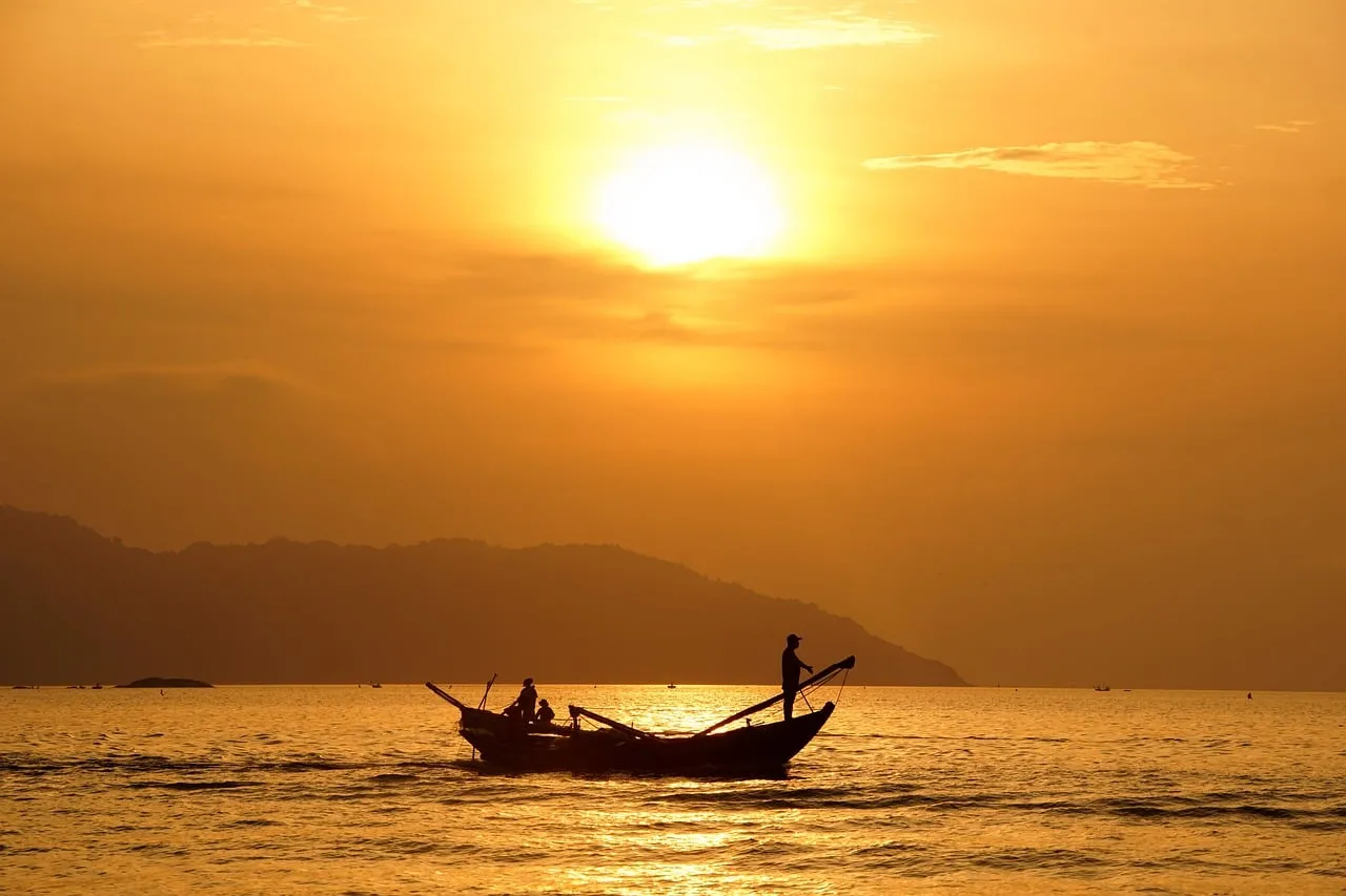 Golden Dawn: Fishermen on Tranquil Waters at Sunrise