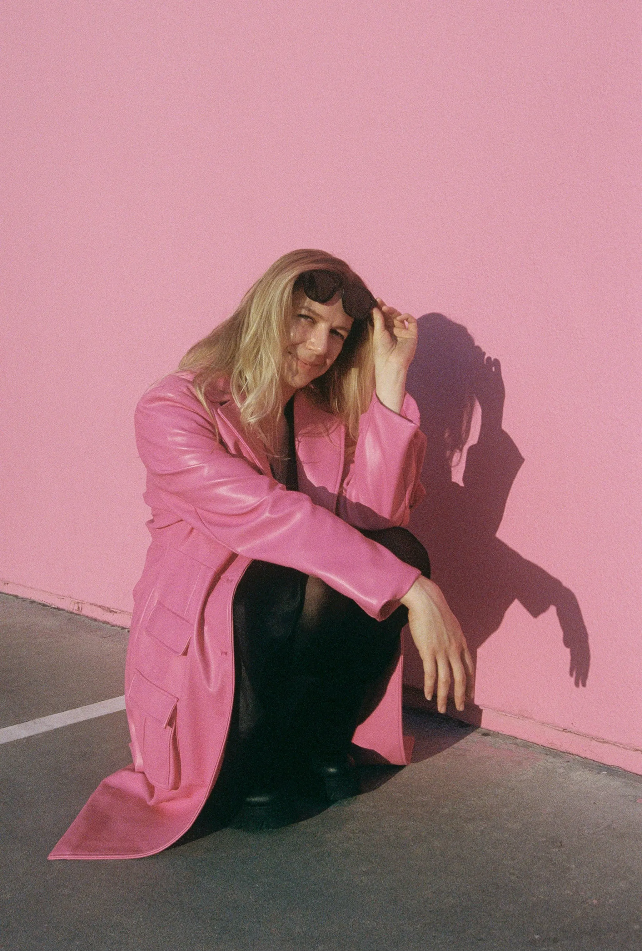 Vibrant Pink: Stylish Woman Poses Against Bold Wall