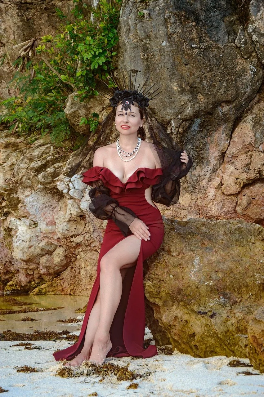 Enchanting Gothic Queen: Red Dress Elegance on a Tropical Beach