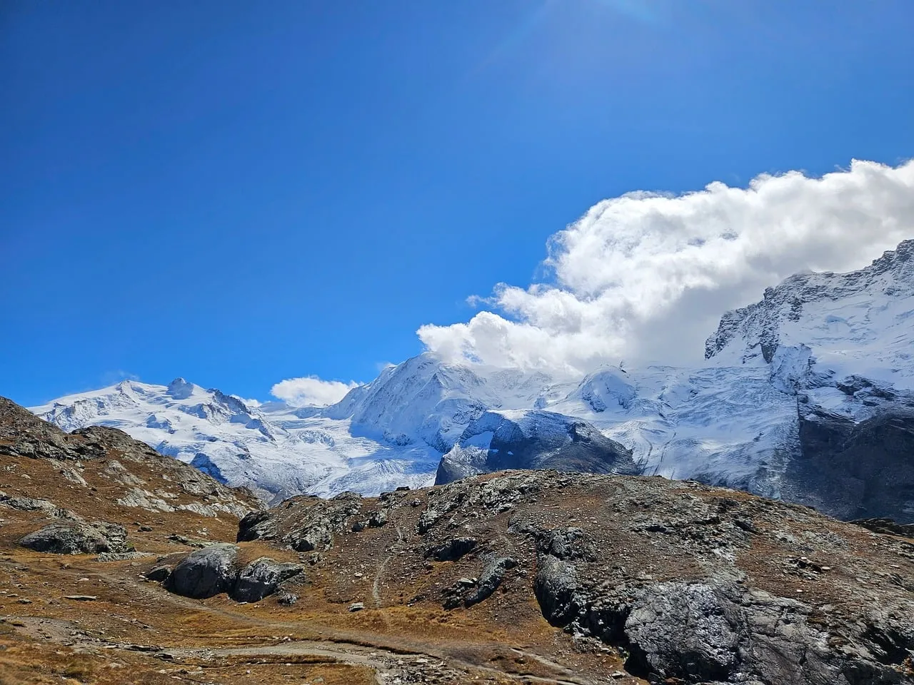 Majestic Alpine Vista: Snowy Peaks Under Azure Sky
