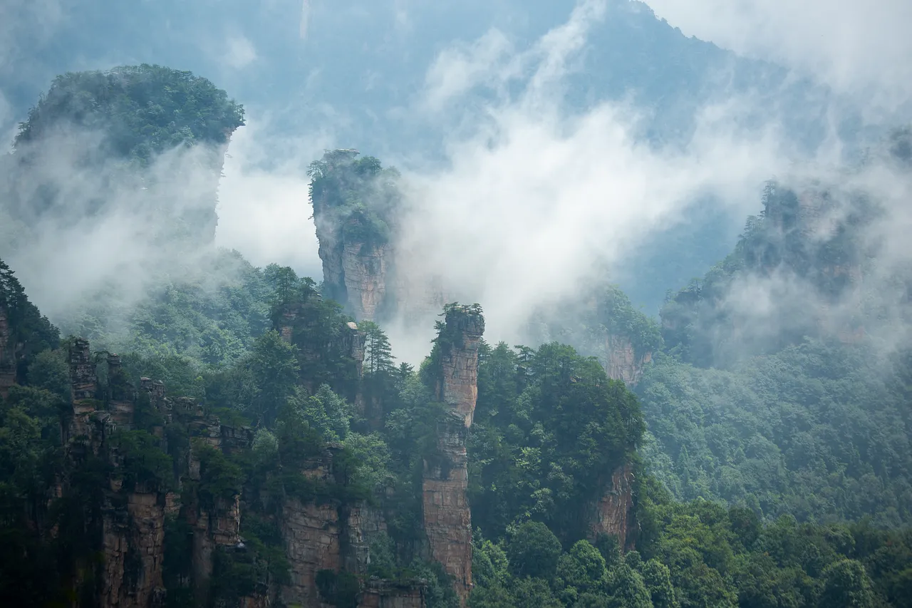 Misty Majesty: Wulingyuan's Enigmatic Peaks Emerge from the Fog