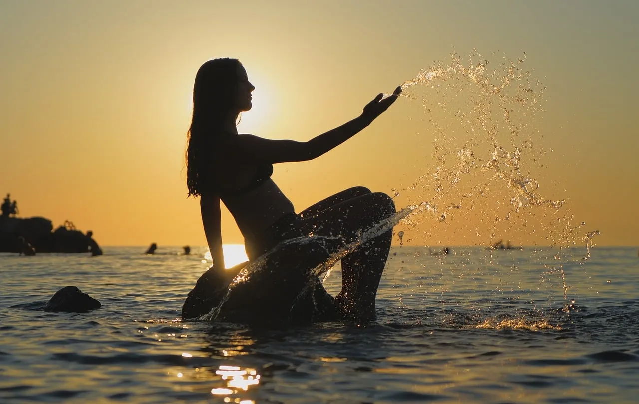 Golden Sunset Serenity: Girl Splashing Water at Beach